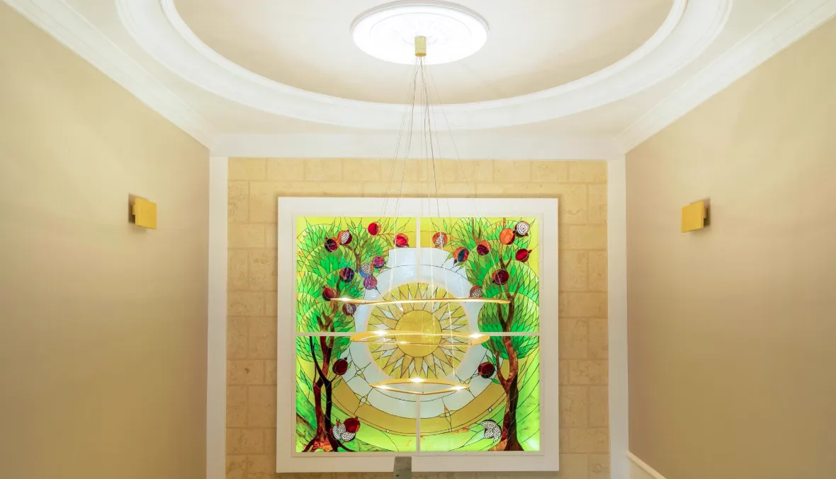 Interior featuring a decorative stained glass wall panel, modern chandelier, and circular ceiling detail.