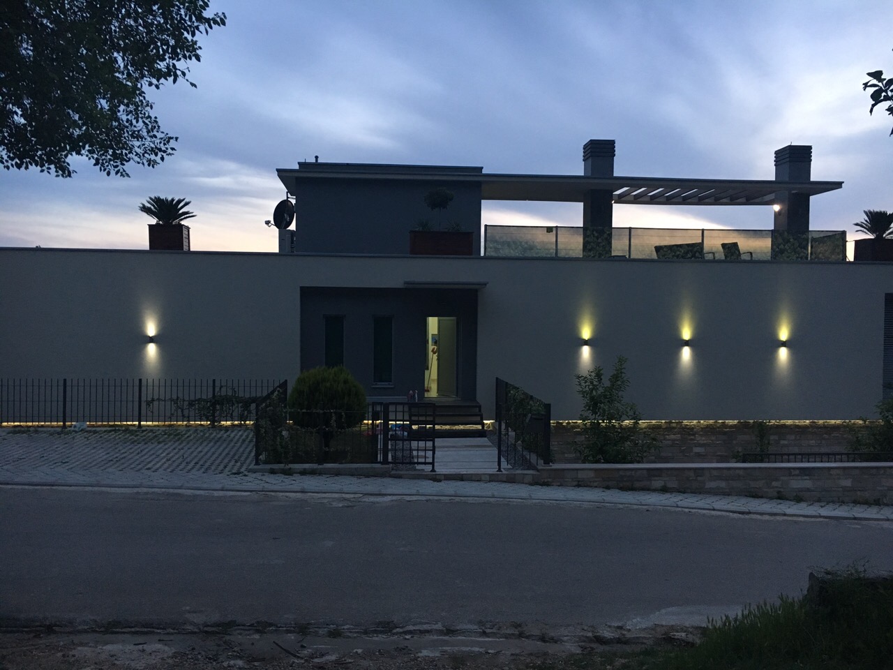 Modern villa in Kotor, Montenegro: illuminated facade, rooftop terrace, and landscaped grounds.