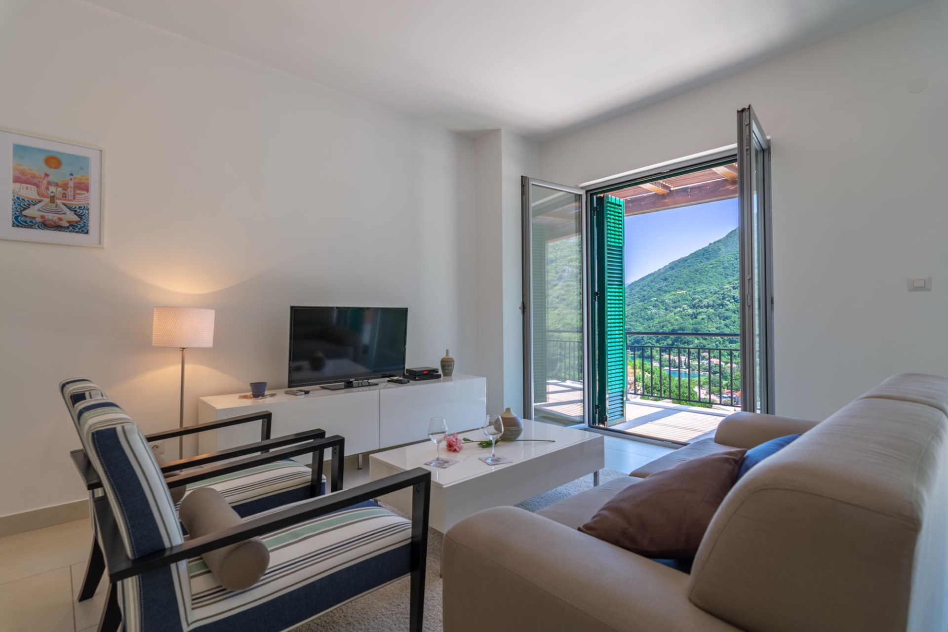 Living room with modern furniture and access to a terrace with mountain views in an apartment, Morinj, Montenegro.