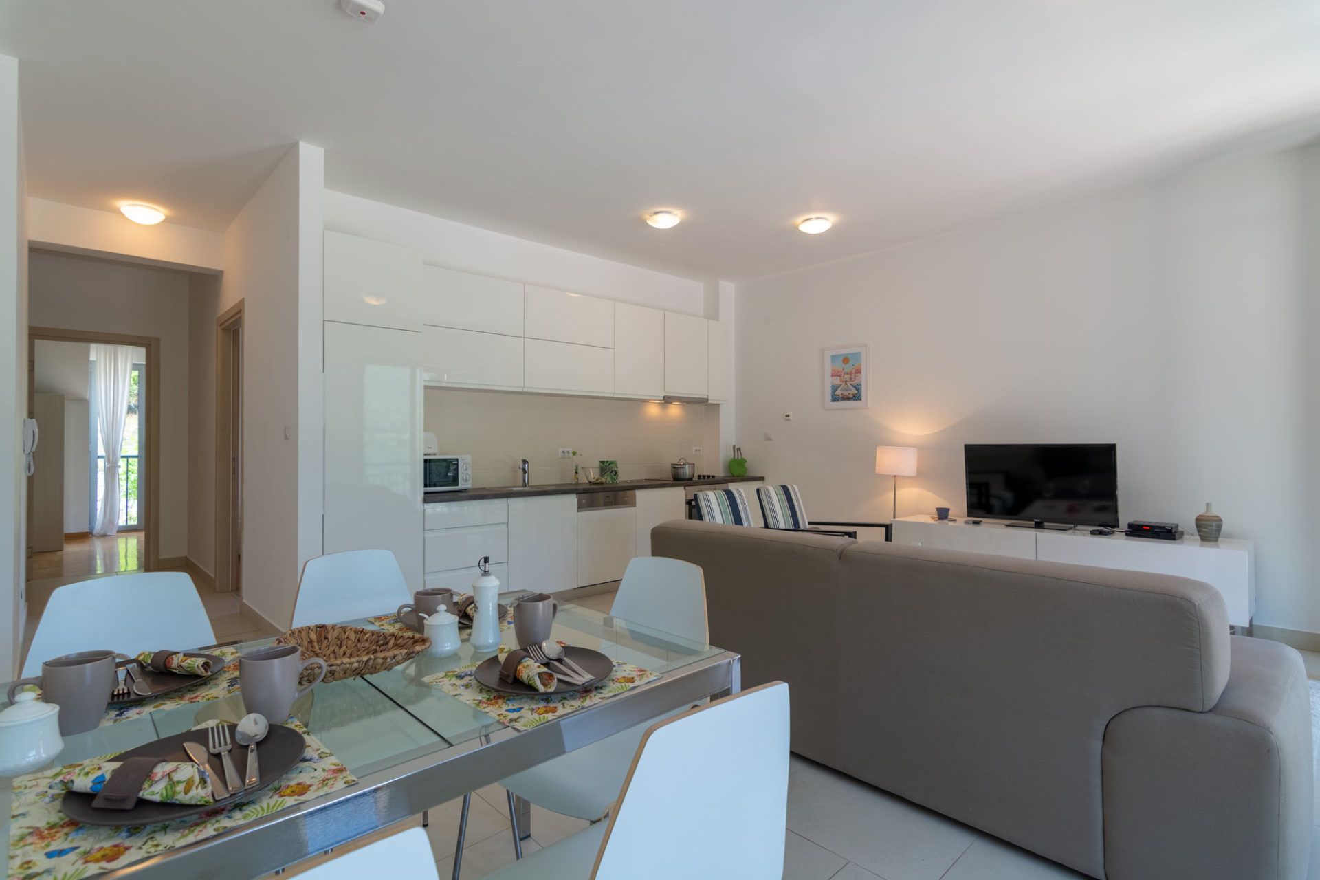 Living room with kitchen in an apartment, Morinj, Montenegro: modern furniture, dining area, and bright interior.