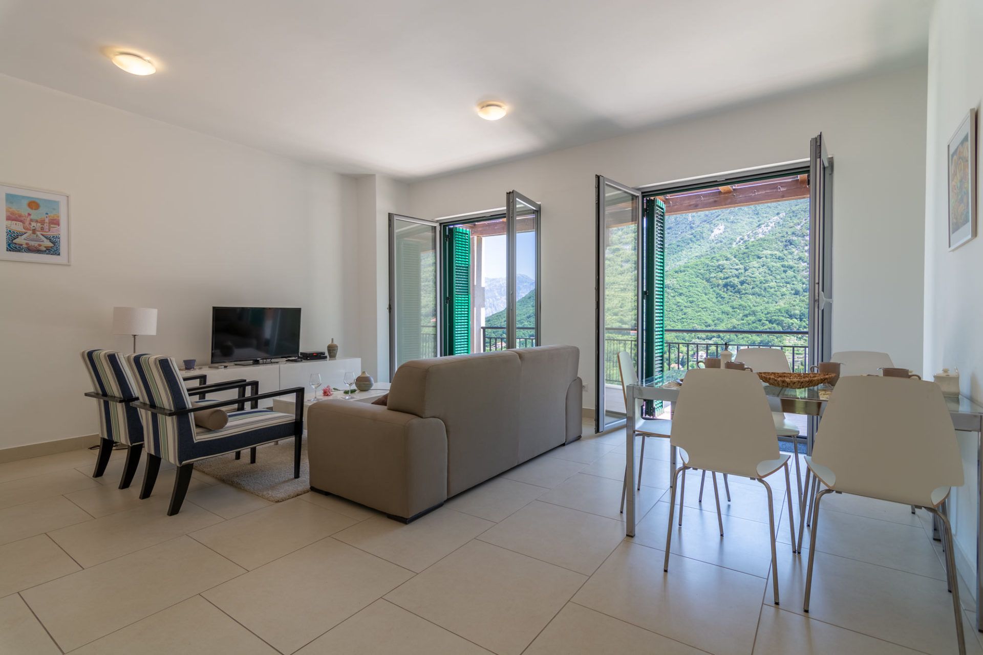 Bright living room with furniture and access to a terrace with mountain views in an apartment, Morinj, Montenegro.