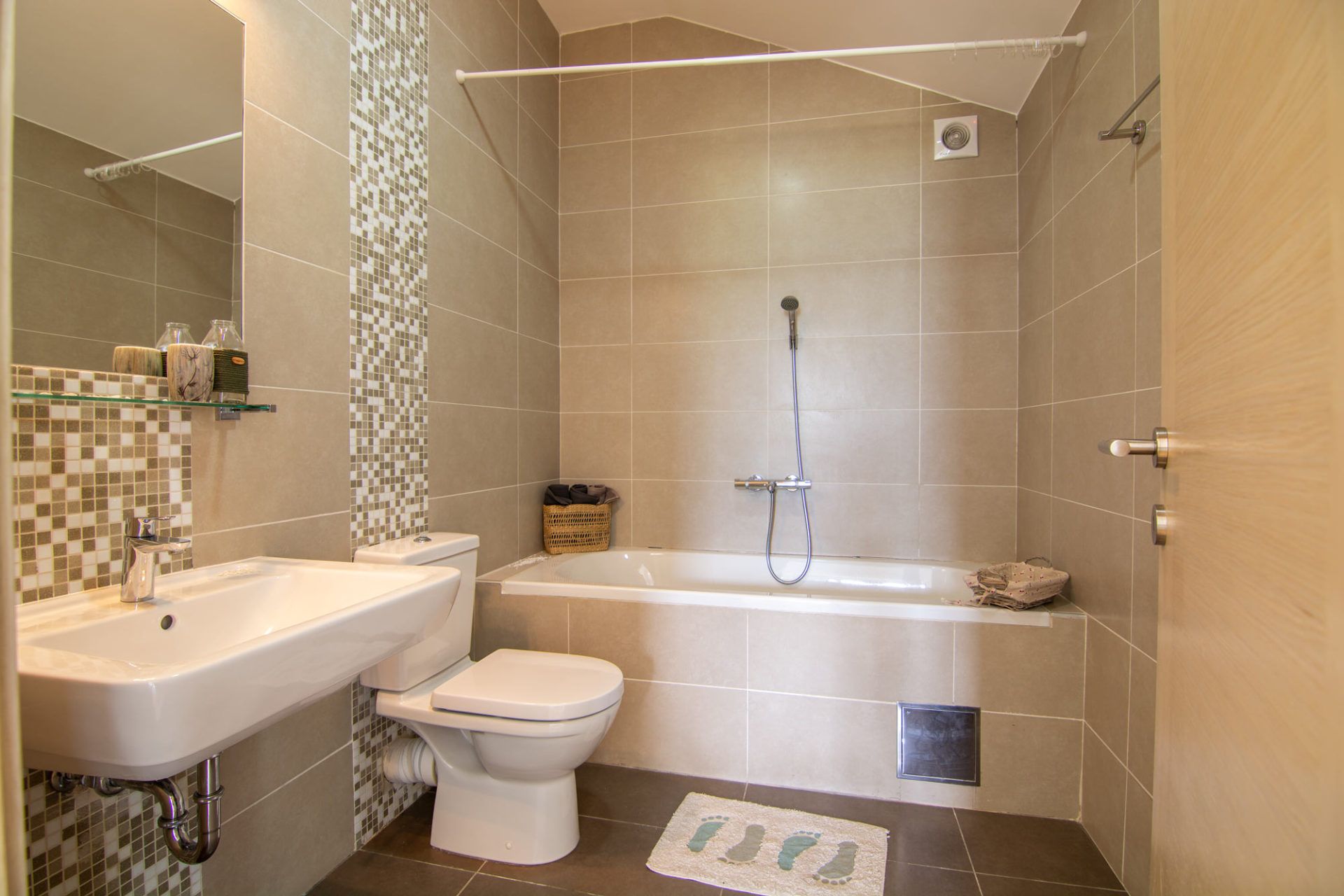 Modern bathroom with tiled walls and a bathtub in apartment No. 1462, Morinj, Montenegro.