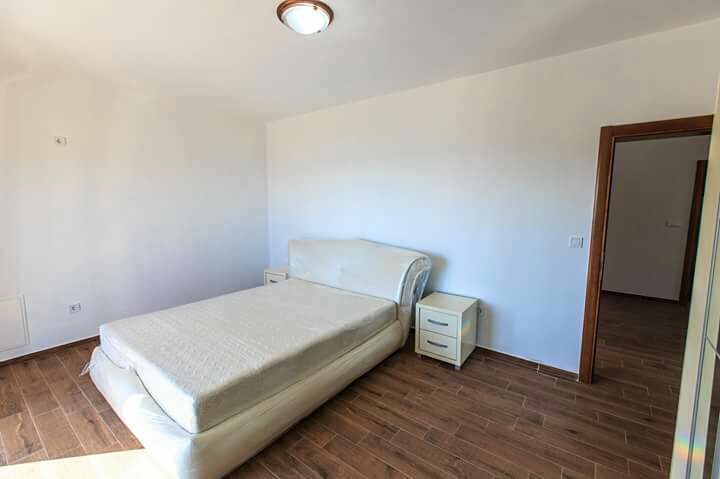 Bright bedroom in a house in Shushan, Montenegro: a double bed, bedside tables, and wood-look tile flooring.