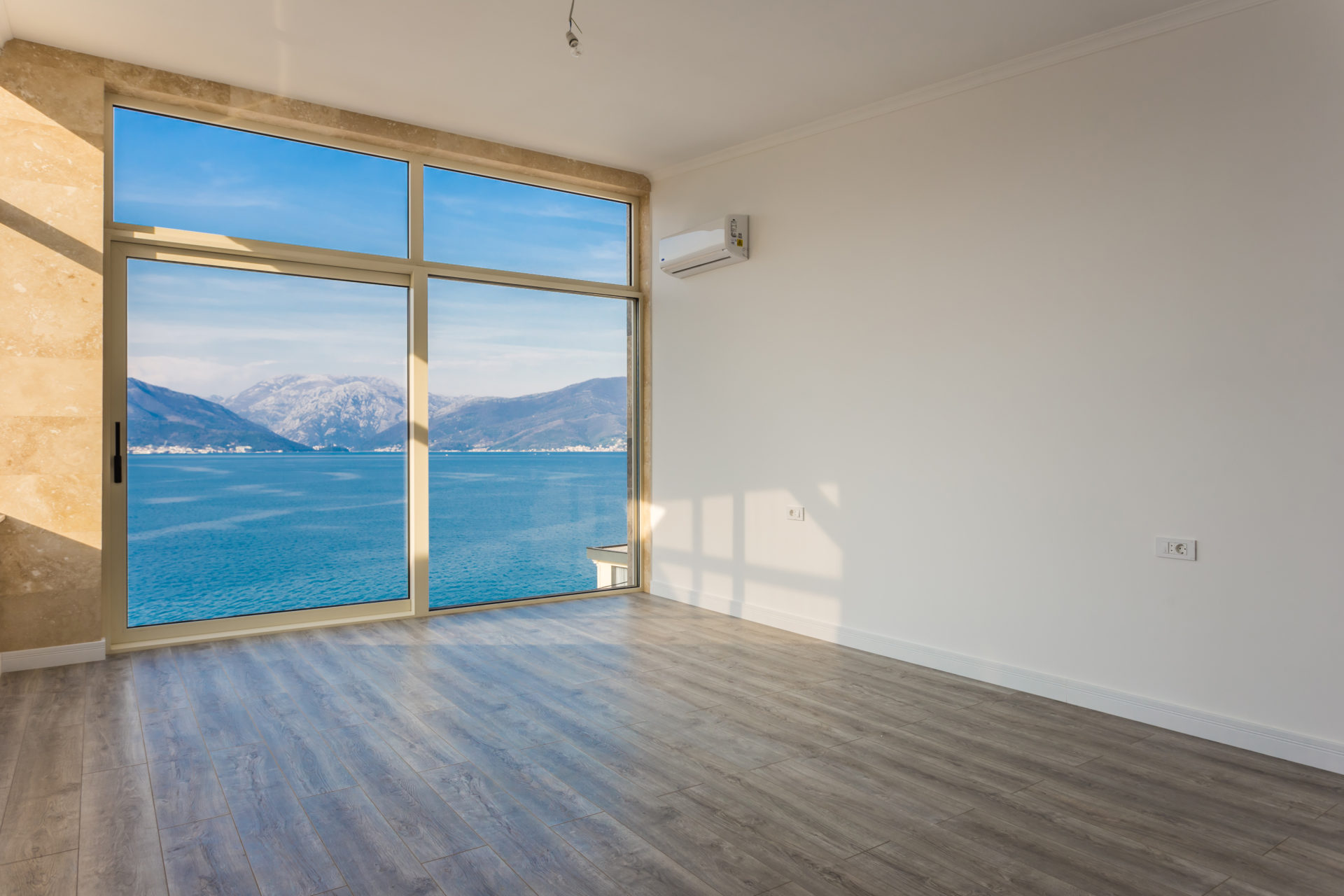 Living room with panoramic sea and mountain views in a villa, Krašići, Montenegro: bright finishes, laminate flooring, and air conditioning.