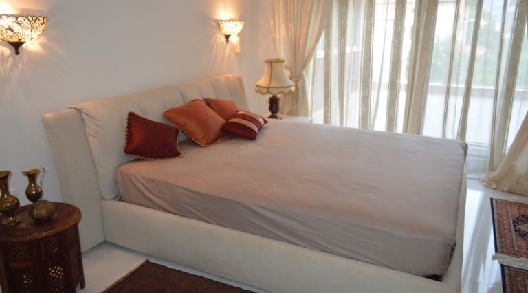 Cozy bedroom with a double bed in an apartment in Ljuta, Montenegro: stylish interior, soft lighting, and decor.
