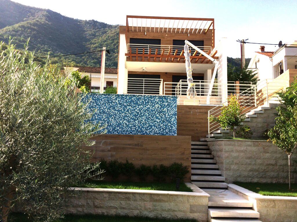 Modern villa in Stoliv, Montenegro: facade with terrace, swimming pool, stone finishes, and mountain views.