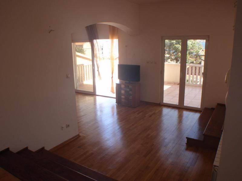 Spacious living room with parquet flooring and access to the terrace in a house, Baošići, Montenegro. View of greenery and a bright interior.