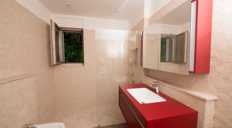 Modern bathroom with a shower cabin and red furniture in a villa in Herceg Novi, Montenegro.