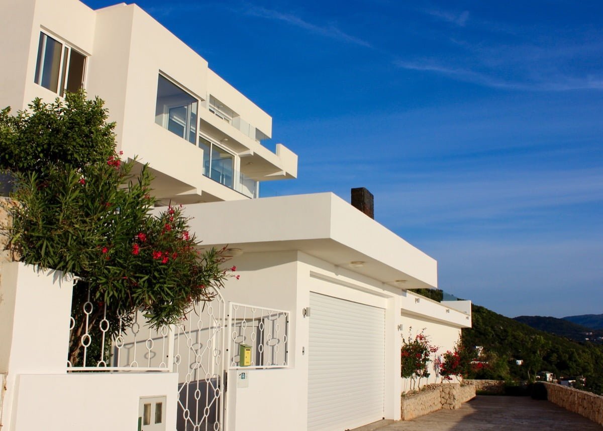 Modern white villa with a garage and terraces in Dobra Voda, Montenegro: exterior view of a luxury house.
