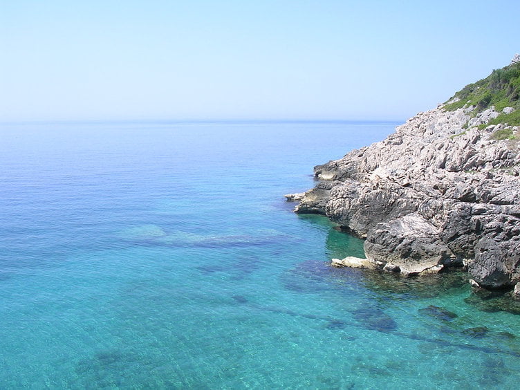 Picturesque view of the Adriatic Sea and rocky shoreline near a house in Dobra Voda, Montenegro.