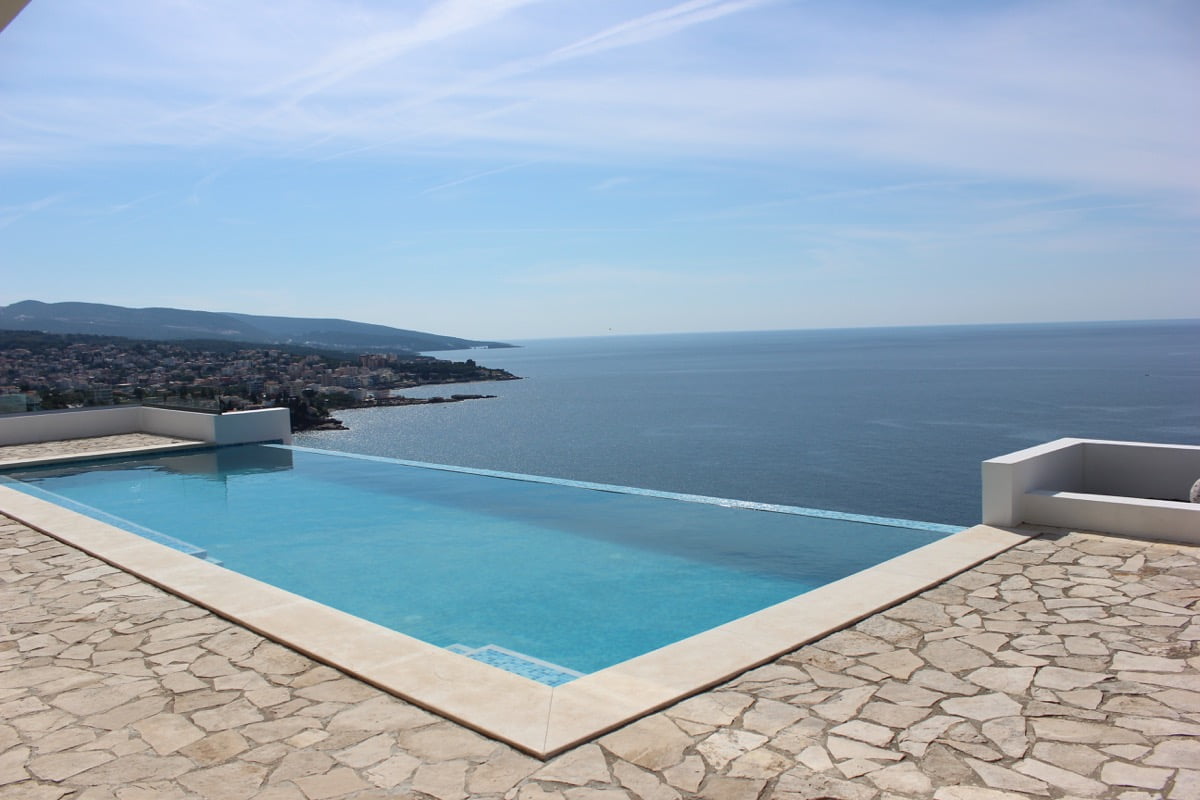 Infinity pool with panoramic views of the sea and coastline in a house, Dobri Vody, Montenegro. Terrace with stone finish.