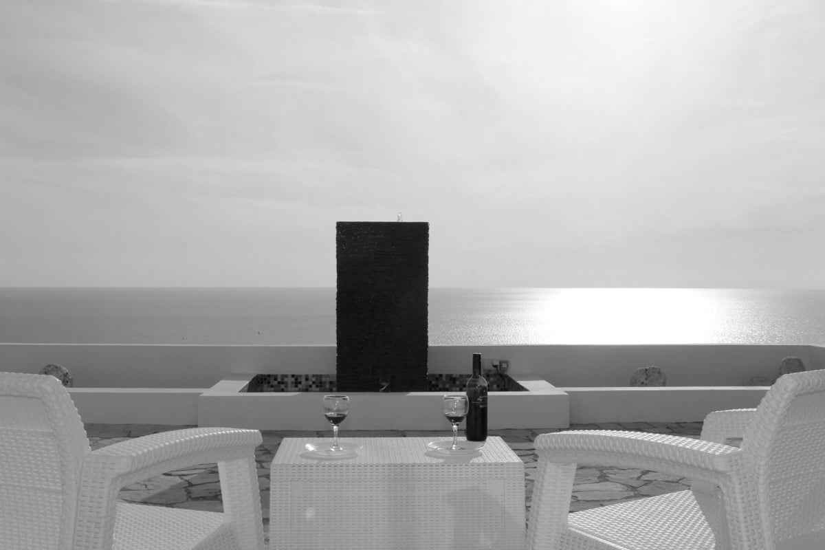 Terrace of a house in Dobra Voda, Montenegro: rattan furniture, a fountain, and a panoramic view of the Adriatic Sea.