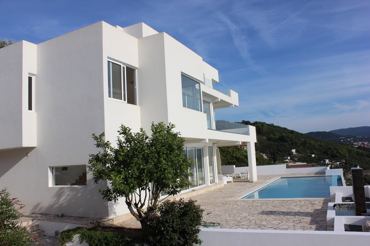 Modern white villa with a pool and terrace in Dobra Voda, Montenegro: view of the house and panoramic windows.