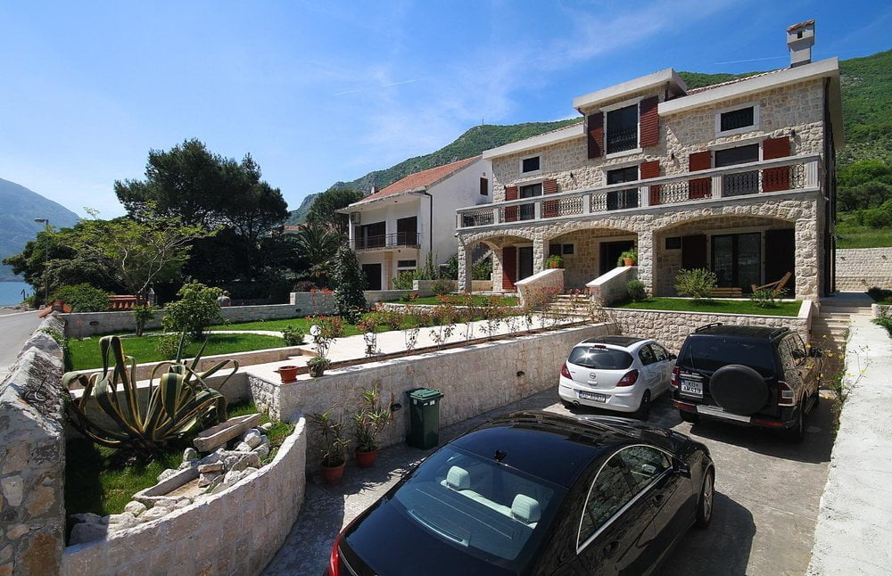 Two-story stone villa in Prčanj, Montenegro, with a terrace, a well-kept garden, and private parking by the sea.