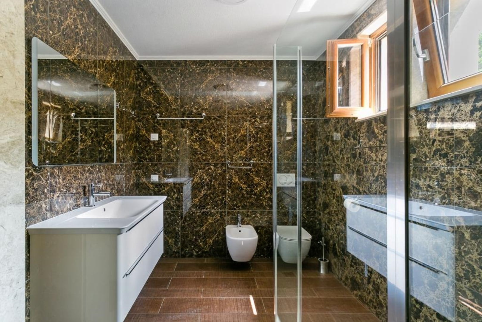 Modern bathroom with dark marble finish and a shower cabin in a villa in Krašići, Montenegro.