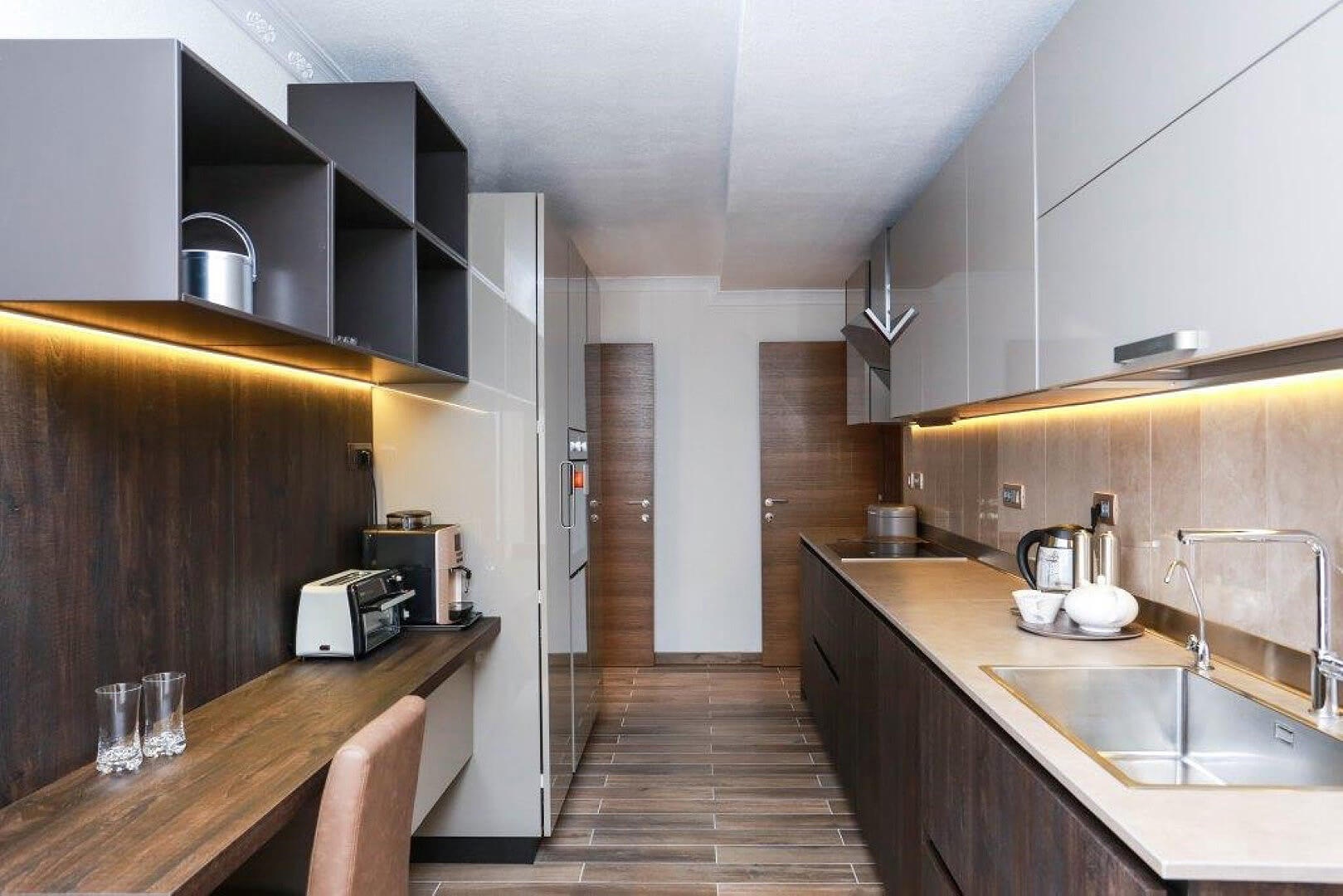 Modern kitchen in a villa in Krašići, Montenegro: glossy fronts, built-in appliances, and stylish lighting.