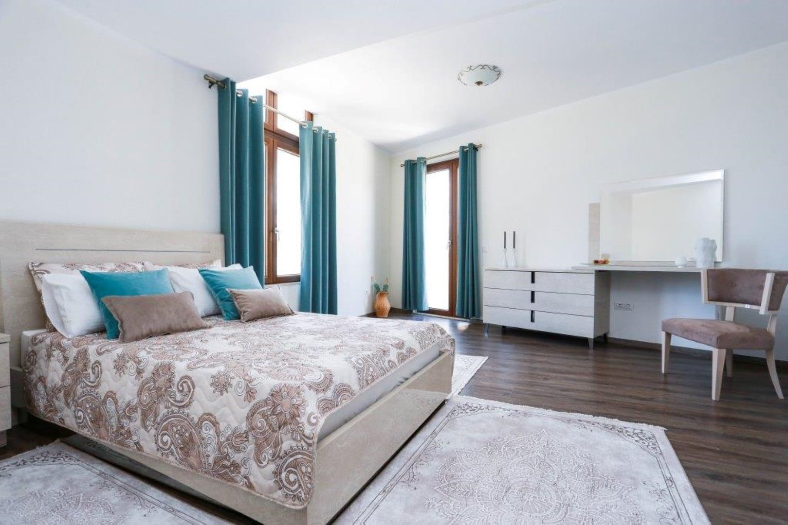 Bright bedroom with a double bed and dressing table in a villa in Krašići, Montenegro.