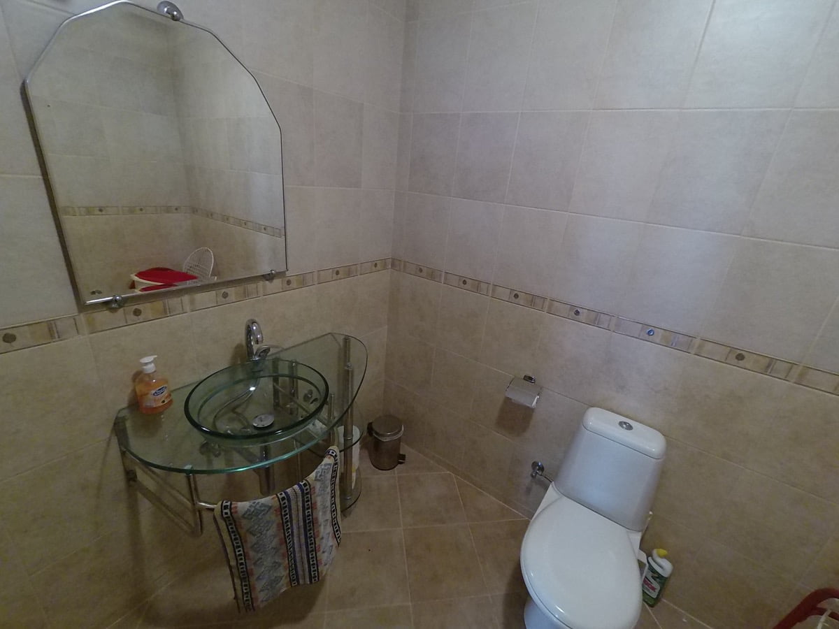 Bathroom with beige tiles, a glass sink, and a mirror in a villa in Prčanj, Montenegro.