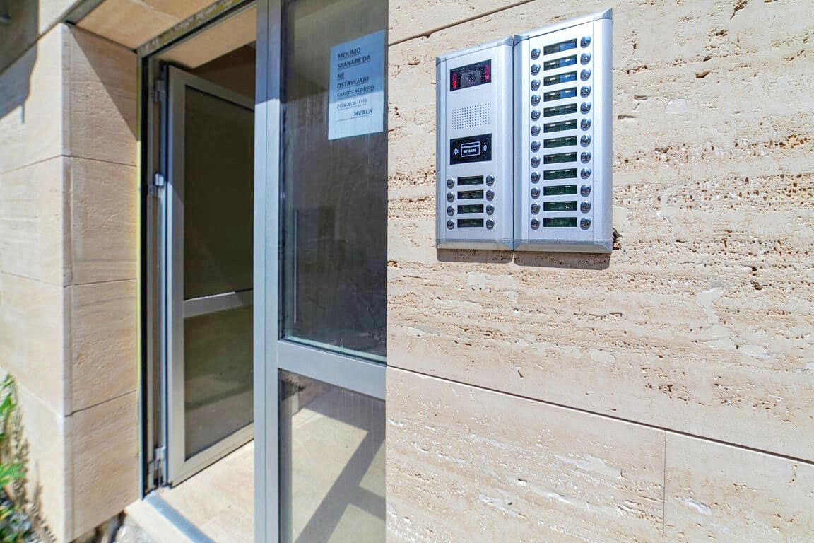 Entrance to a residential building with an intercom and natural stone finishes in the Bay of Kotor, Montenegro.