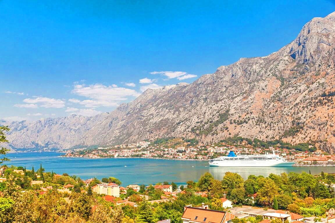 Panoramic view of the Bay of Kotor, mountains, and a cruise ship from an apartment in Kotor, Montenegro.