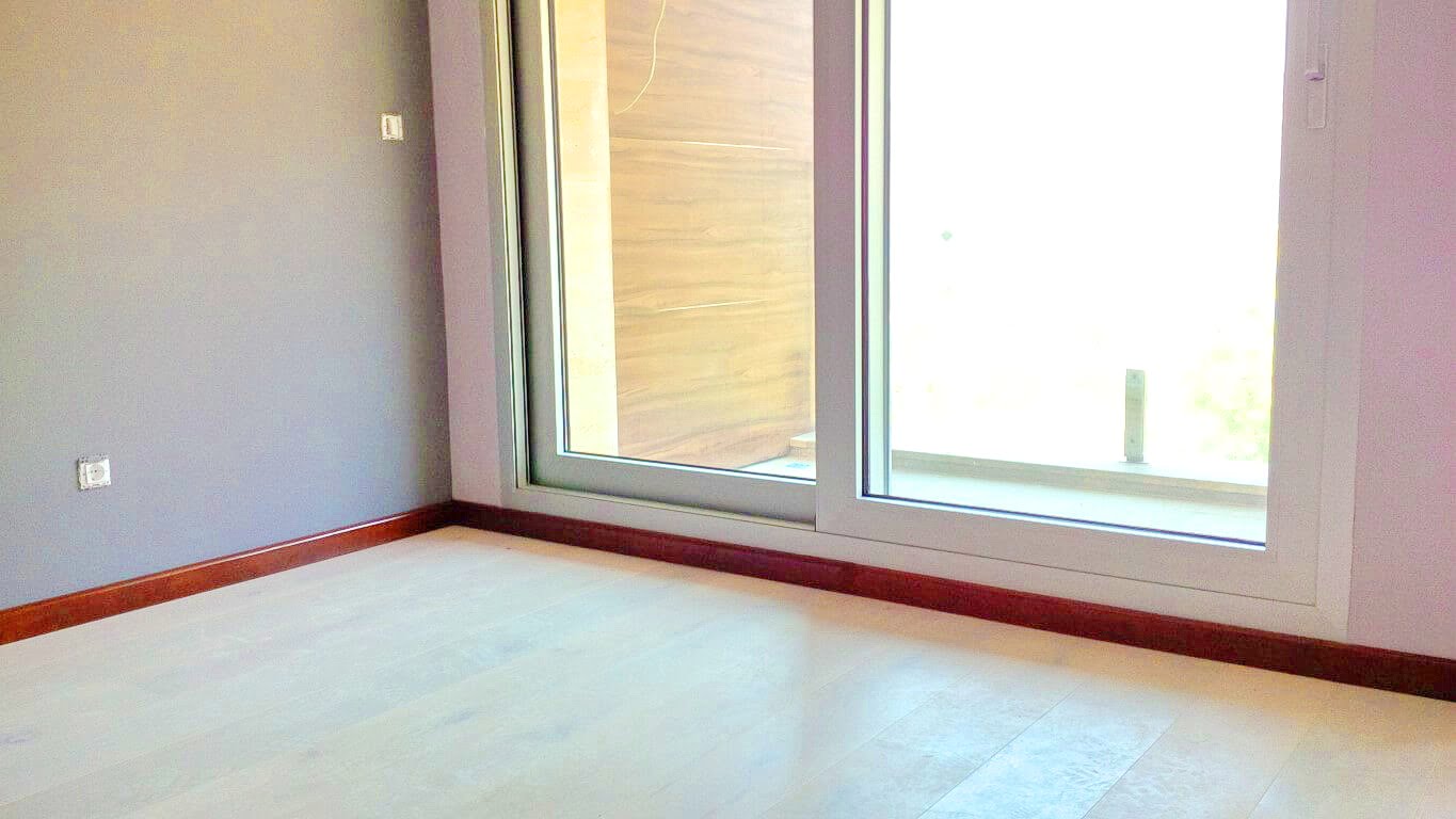 Bright living room with a panoramic window and access to the terrace in an apartment, Kotor, Montenegro. Modern interior finish.