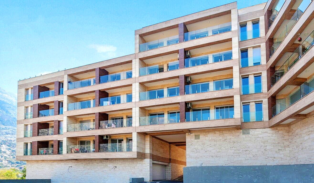 Modern residential complex with balconies and stone facade cladding in the Bay of Kotor, Montenegro.