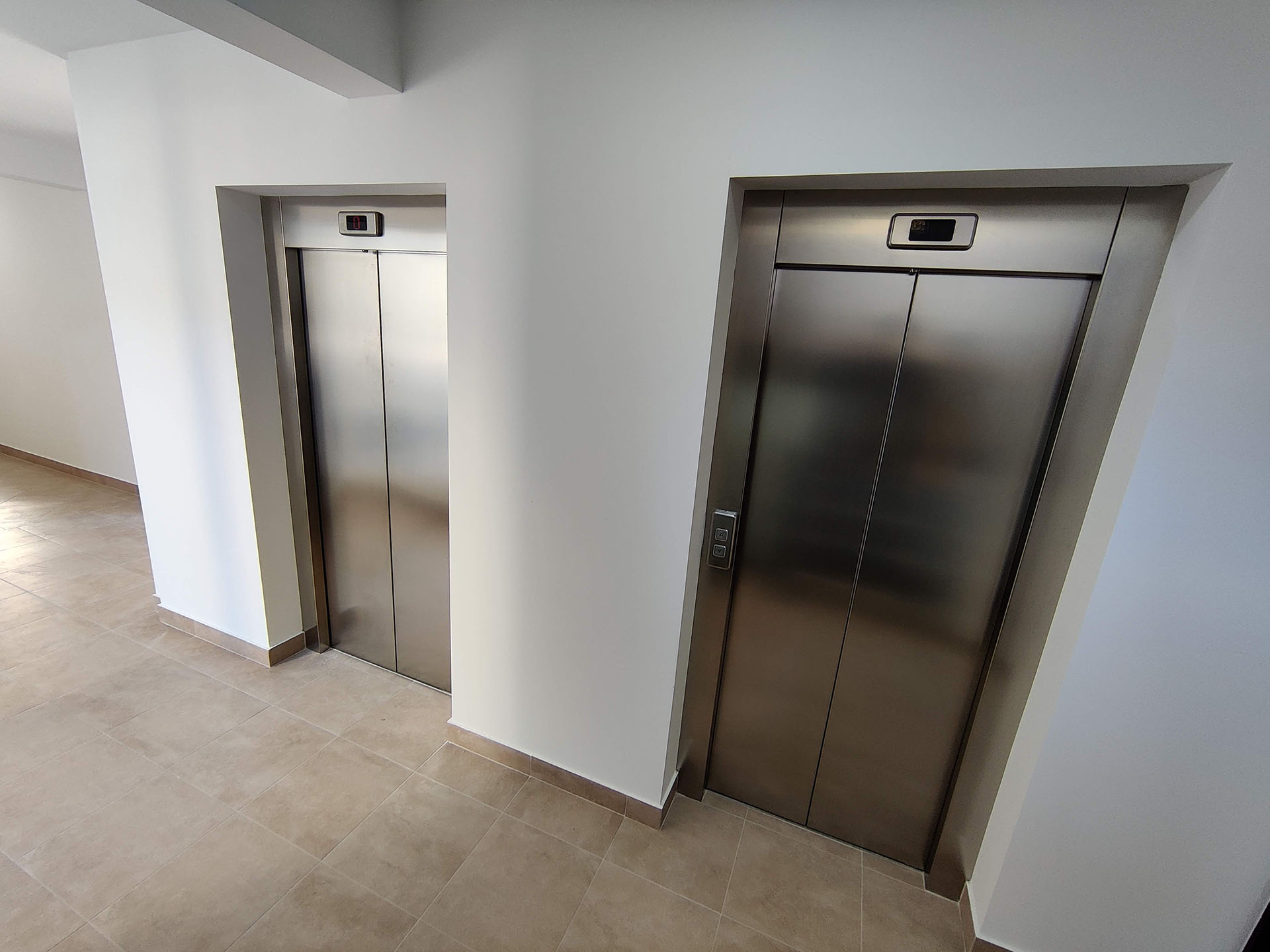 Modern elevator lobby with metal doors in a residential complex in Bečići, Montenegro.