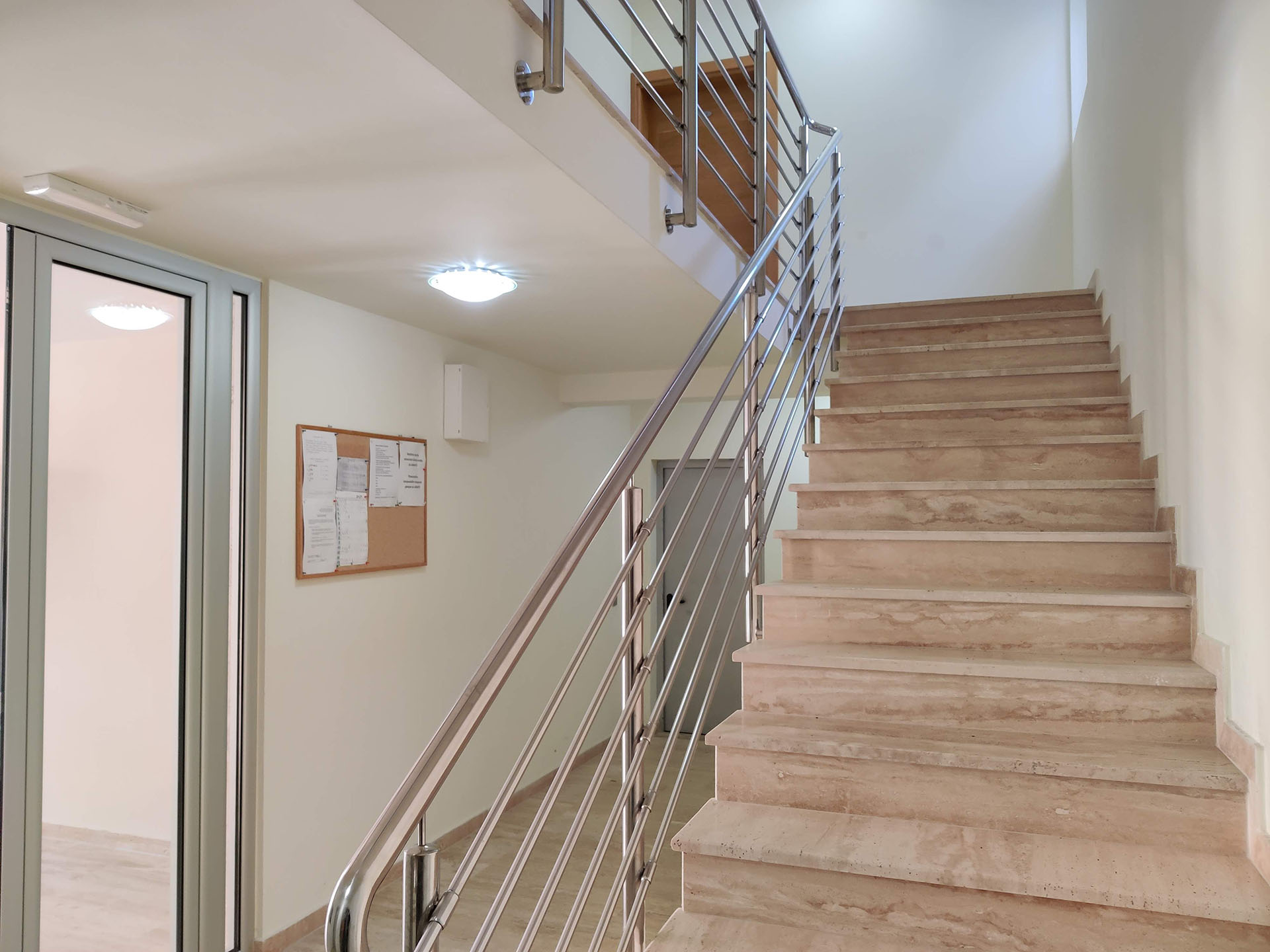 Staircase with marble steps and metal railings in the entrance hall of a residential complex in Bečići, Montenegro.