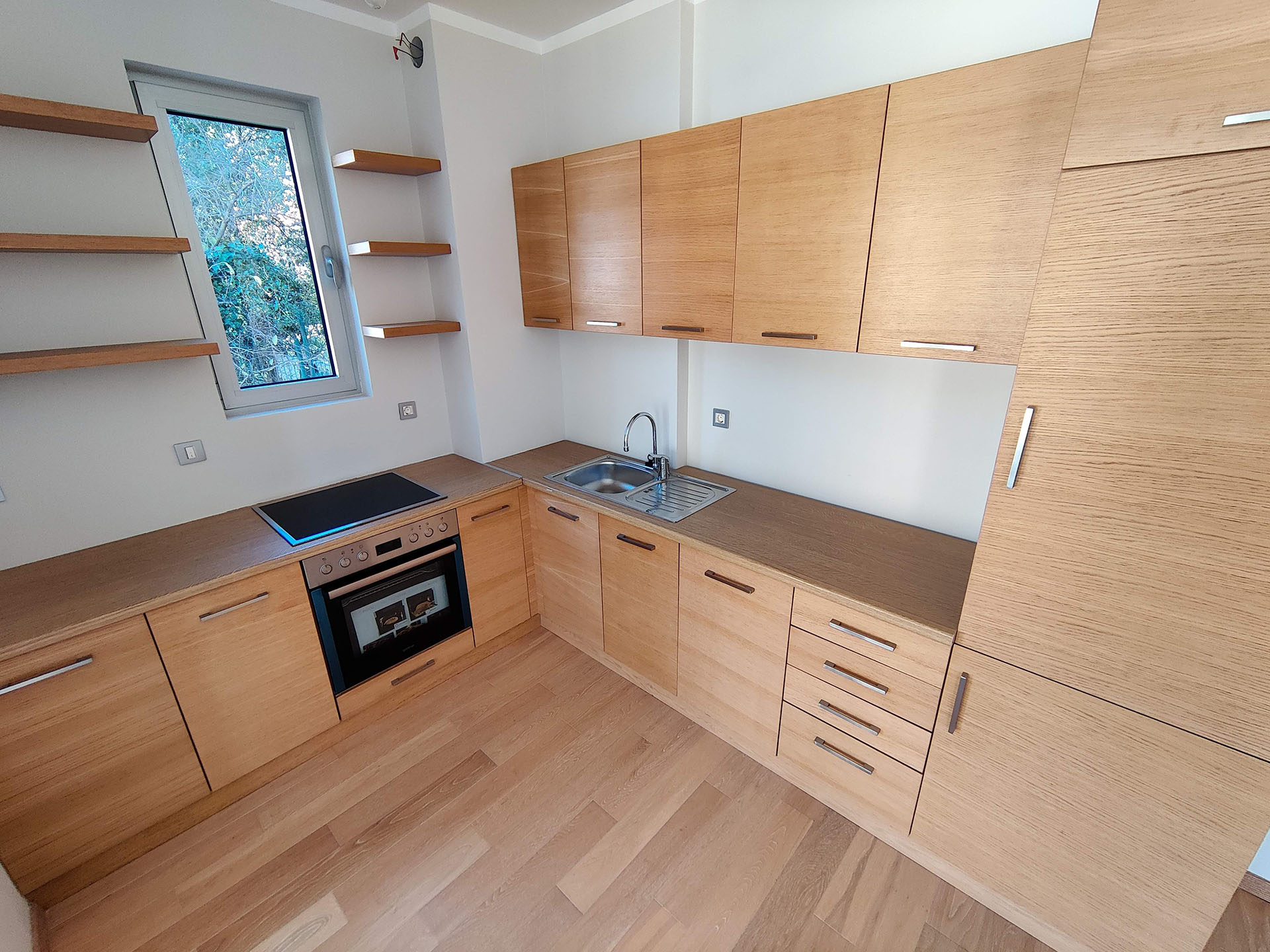 Modern kitchen with wooden фасades and built-in appliances in an apartment, Bečići, Montenegro.