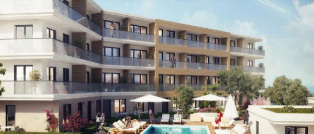 Modern residential complex with a swimming pool and terraces in Kavač, Montenegro: view of the building facade and relaxation area.