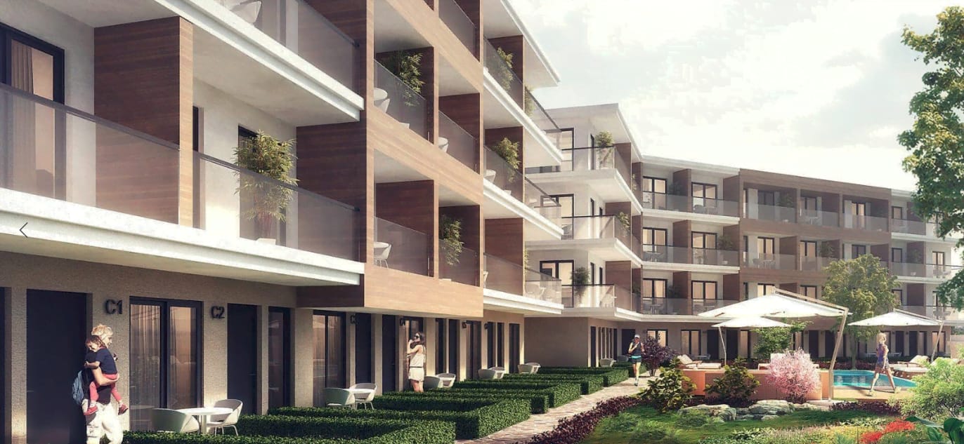 Exterior view of a modern apartment complex featuring balconies, landscaped gardens, and a pool area.