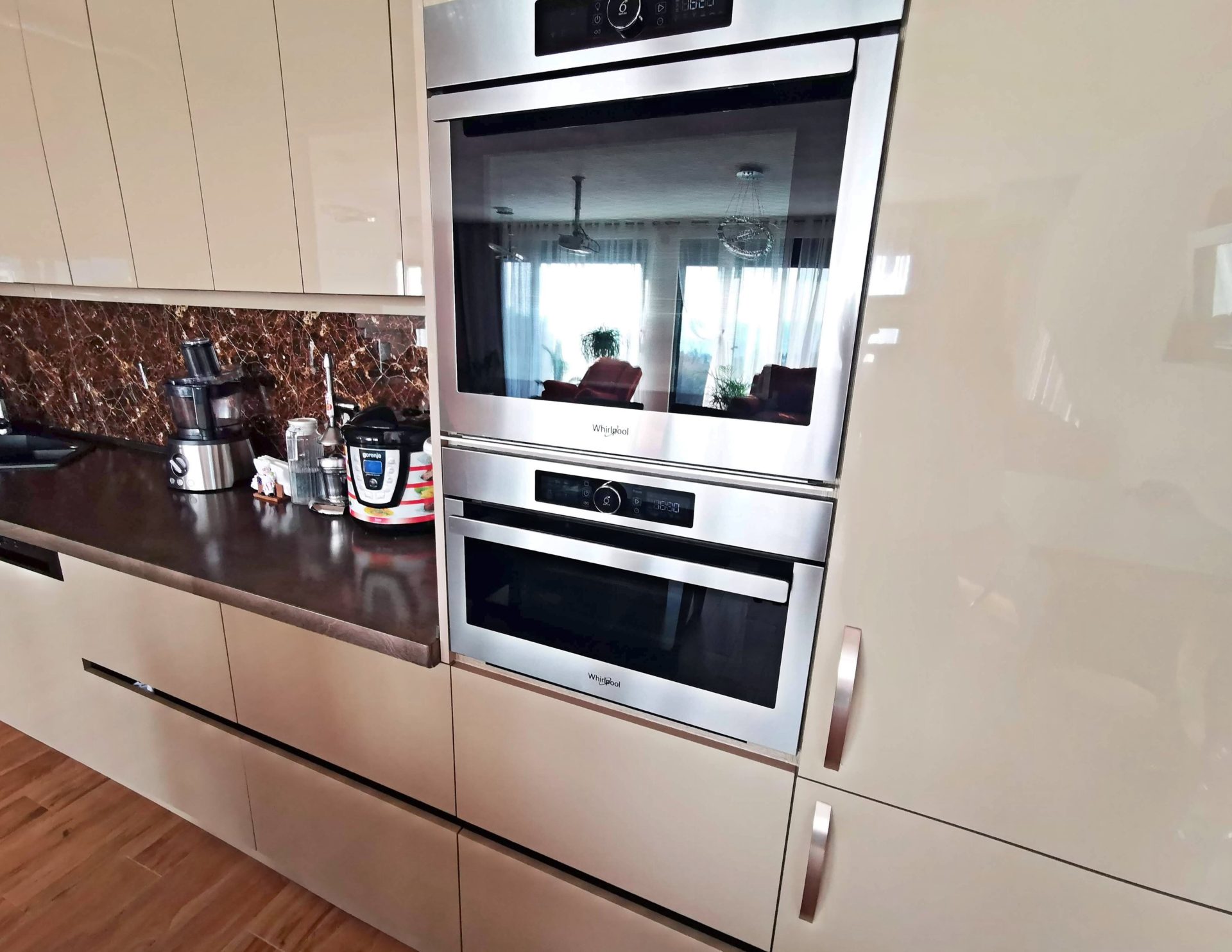 Modern kitchen in a villa in Bar, Montenegro: built-in Whirlpool appliances, glossy cabinet fronts, and a marble backsplash.
