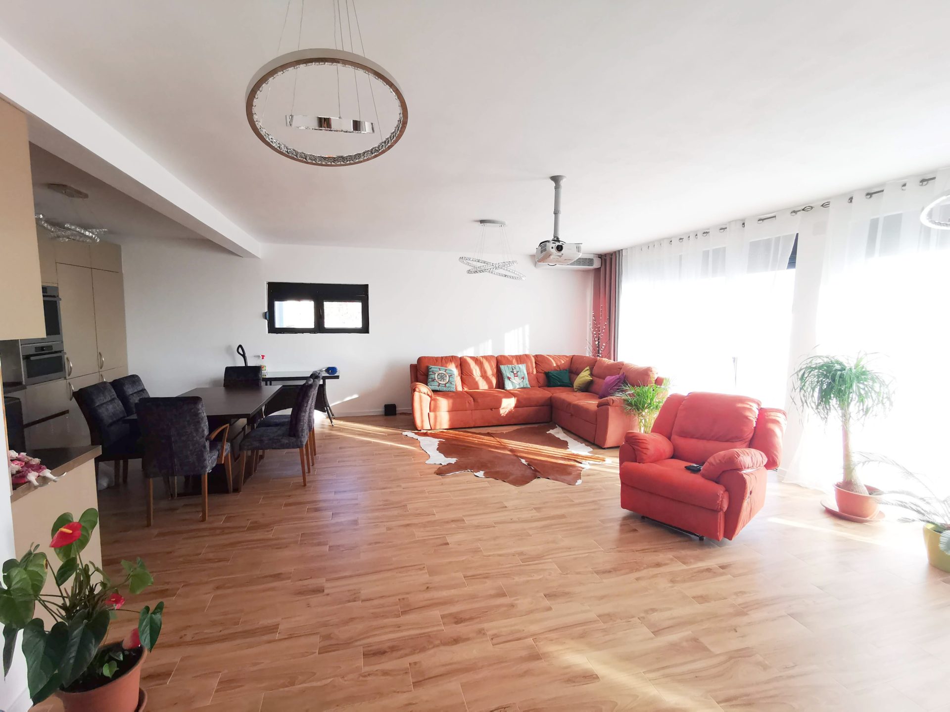 Spacious living room with an orange sofa and dining area in a villa in Bar, Montenegro.
