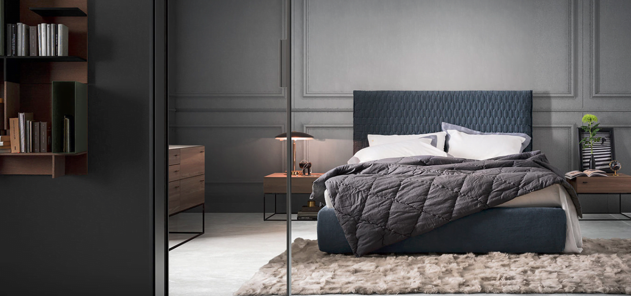 Modern bedroom in a residential complex in Rafailovići, Montenegro: blue bed, wooden furniture, and stylish decor.