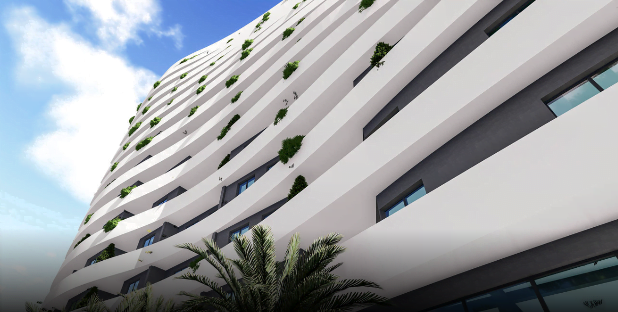 Modern residential complex with curved white facades and landscaping in Rafailovići, Montenegro. View of the building from below.