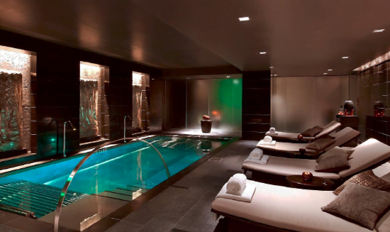Indoor swimming pool with lighting and lounge area in a luxury residential complex in Rafailovići, Montenegro.