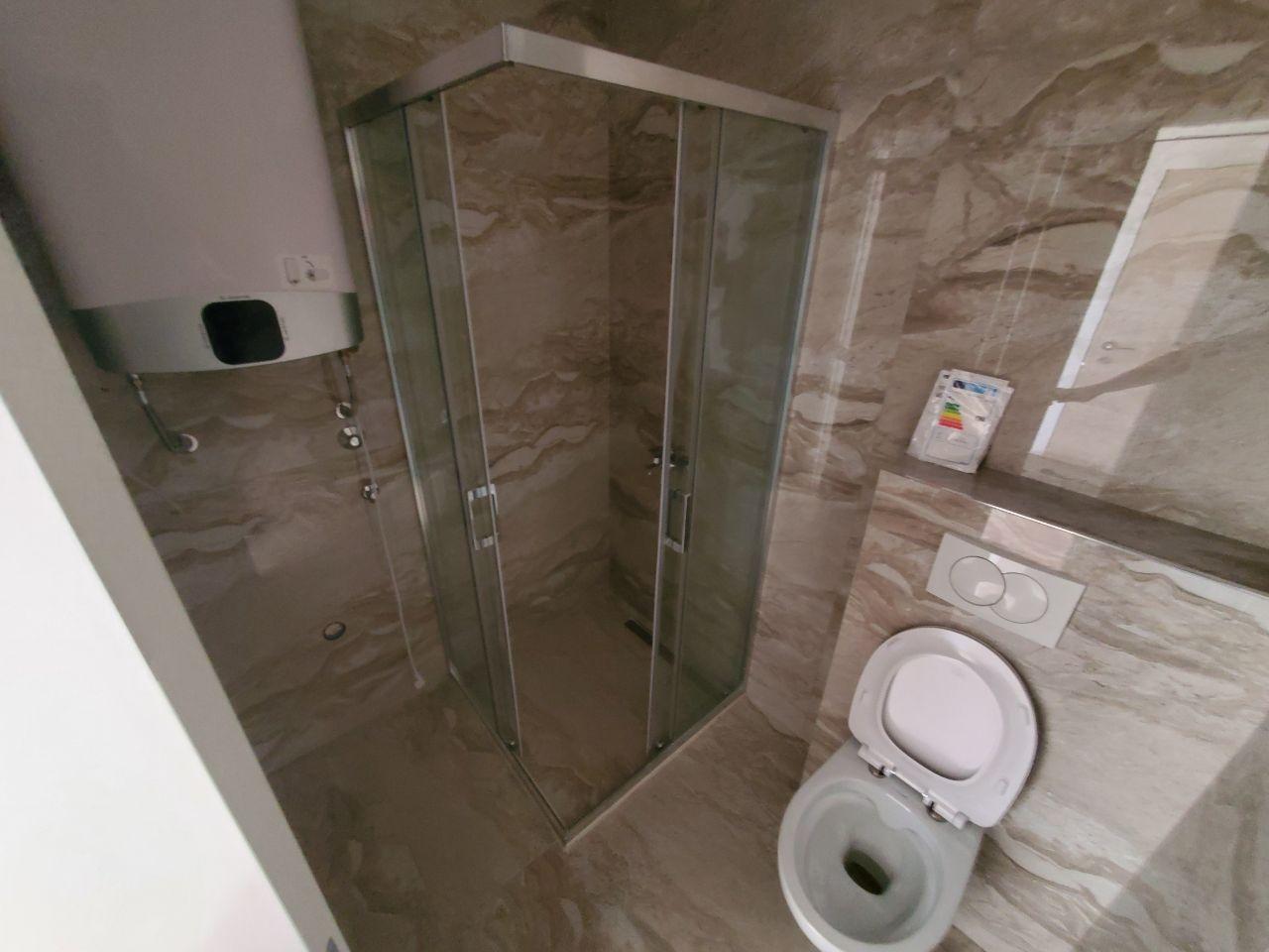 Modern bathroom with a shower cabin and tiled finishes in a residential building in Bečići, Montenegro.