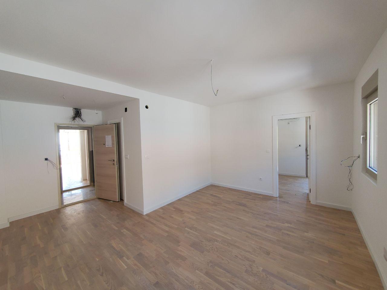 Bright living room with finished interior and parquet flooring in a new residential building in Bečići, Montenegro.