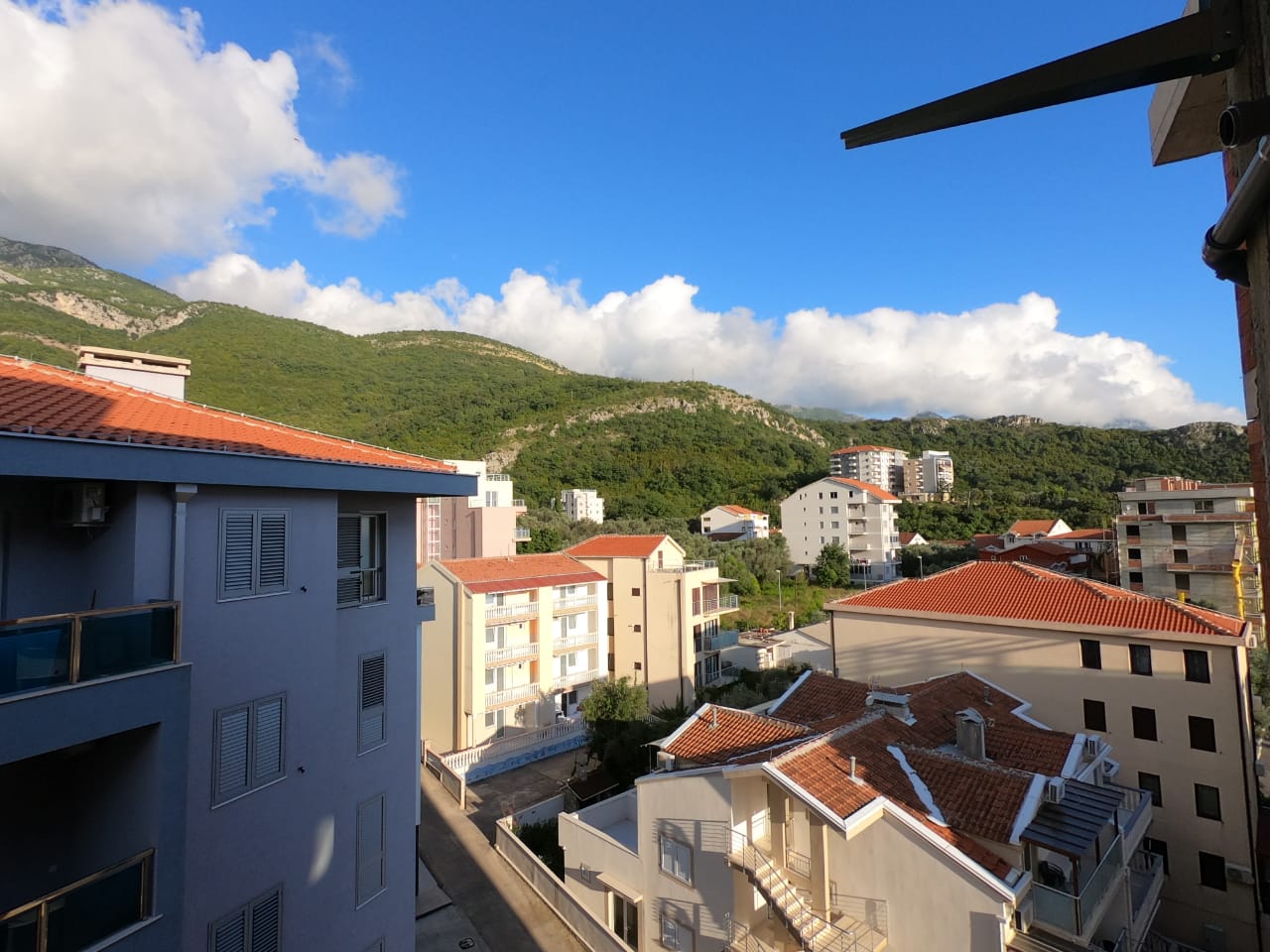 View from the balcony of a residential complex and green mountains in Bečići, Montenegro, sunny day, seaside real estate.