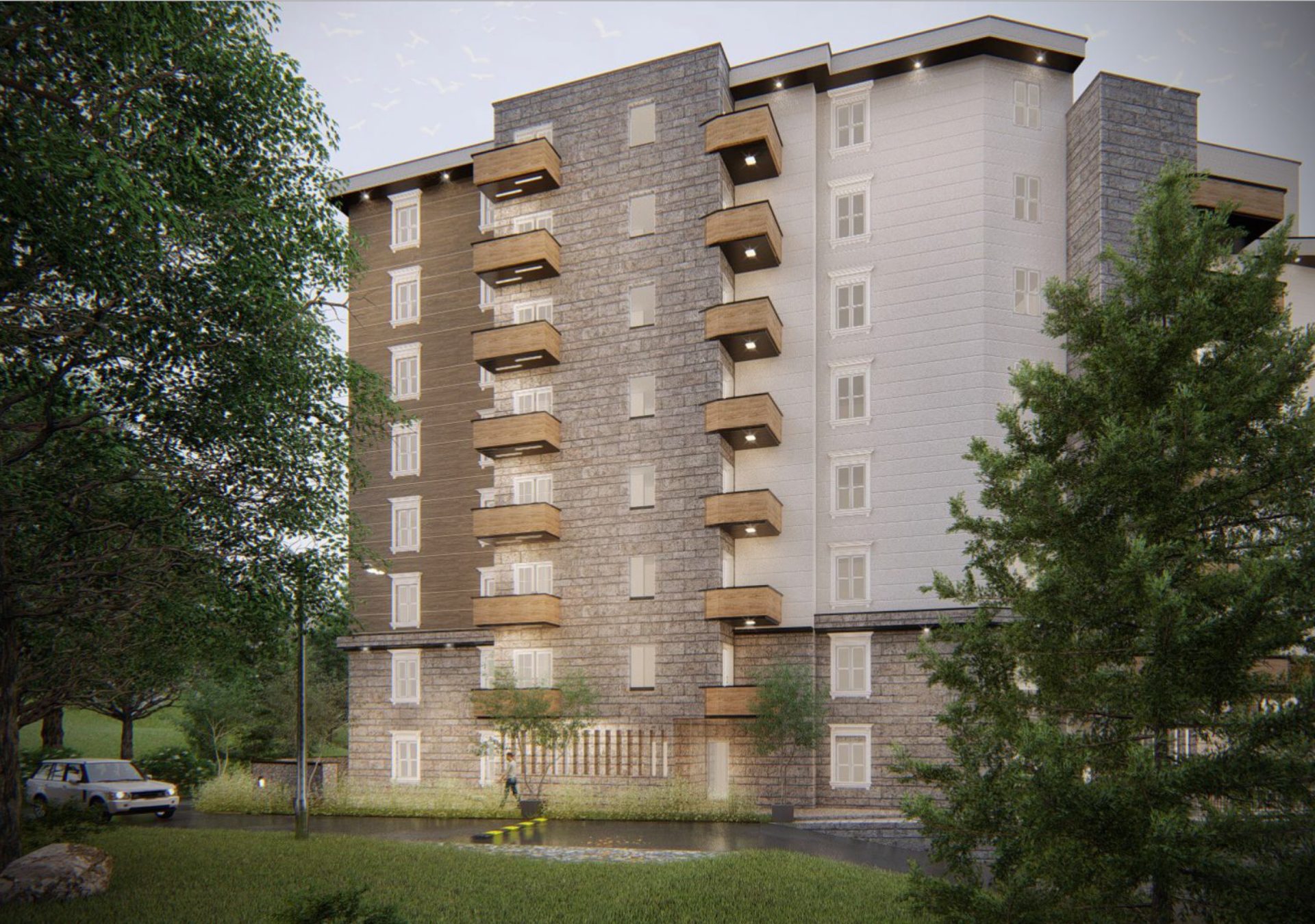Modern residential building in Bečići, Montenegro: facade with stone cladding, balconies, and lighting surrounded by greenery.