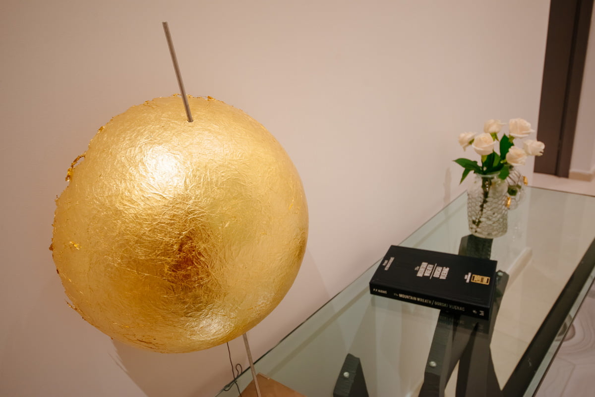 A golden art object and a glass table with flowers in the interior of a luxury apartment in Kumbor, Montenegro.