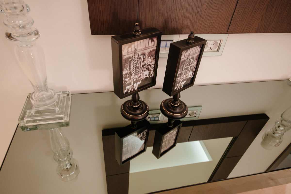 Living room decor in an apartment in a complex in Kumbor, Montenegro: a glass table, vintage frames, and a designer lamp.