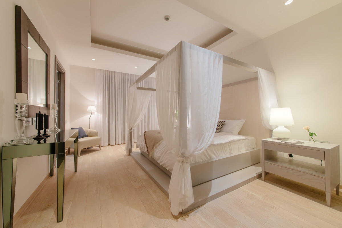 Bright bedroom with a canopy bed in a luxury apartment in Kumbor, Montenegro: modern design and decor.