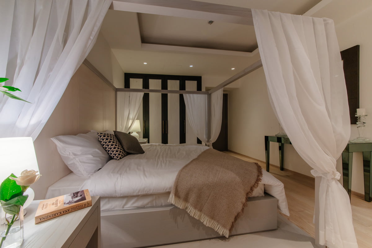 Bedroom with a canopy bed in an apartment in a complex in Kumbor, Montenegro: stylish interior and modern furniture.