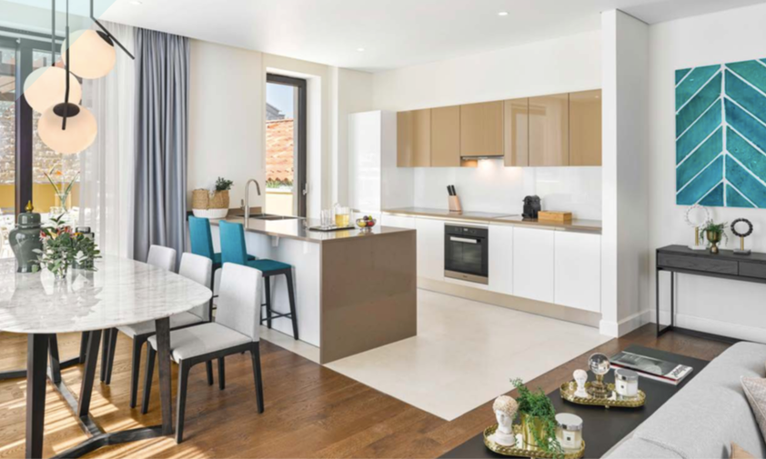 Modern kitchen-living room in the Porto Novi complex, Kumbor, Montenegro: white furniture, marble table, and view of the terrace.