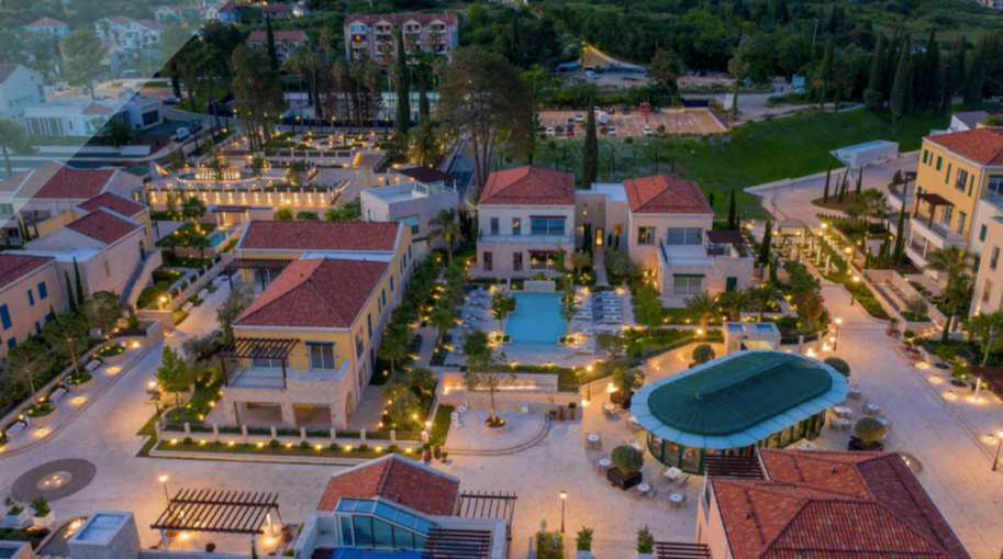 Aerial view of the luxury Porto Novi residential complex in Kumbor, Montenegro: villas, a swimming pool, and landscaped grounds.