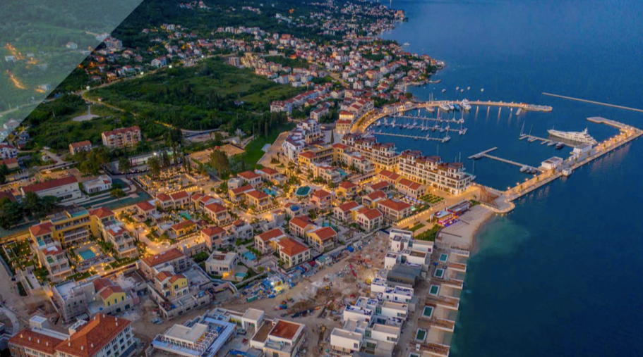 Panoramic aerial view of the Porto Novi resort complex in Kumbor, Montenegro, with the marina and evening lighting.