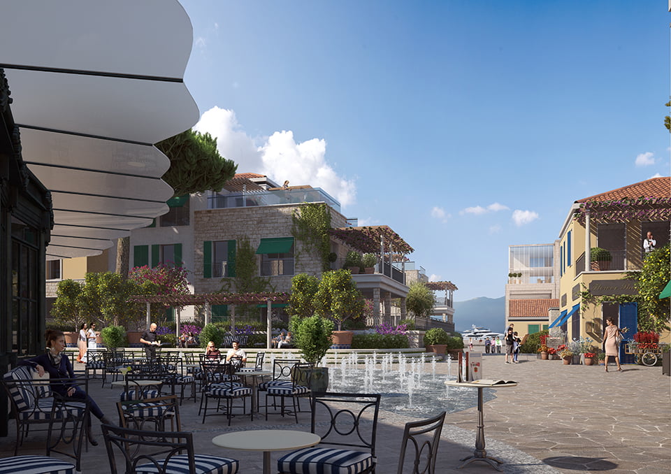 View of the café summer terrace with a fountain and stone villas in the exclusive Porto Novi complex, Kumbor, Montenegro.