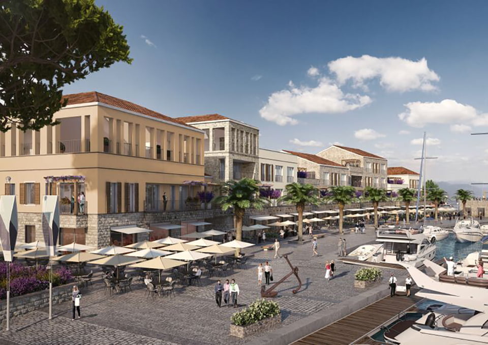 View of the luxury Porto Novi residential complex in Kumbor, Montenegro: the waterfront promenade with yachts, restaurants, and stone architecture.