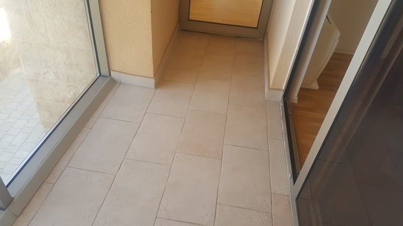 Bright balcony with floor tiles and panoramic glazing in an apartment, Bečići, Montenegro.